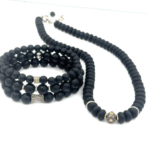 black beaded necklace and 3 bracelets each featuring different diamond components
